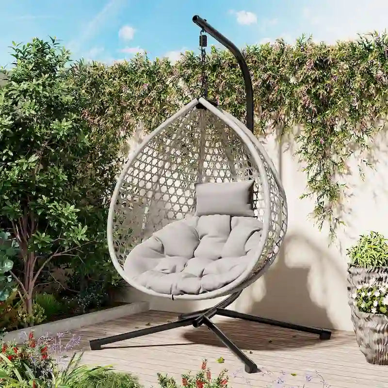 Fauteuil suspendu polyvalent pour l'intérieur et l'extérieur, en rotin PE, avec support et coussin.