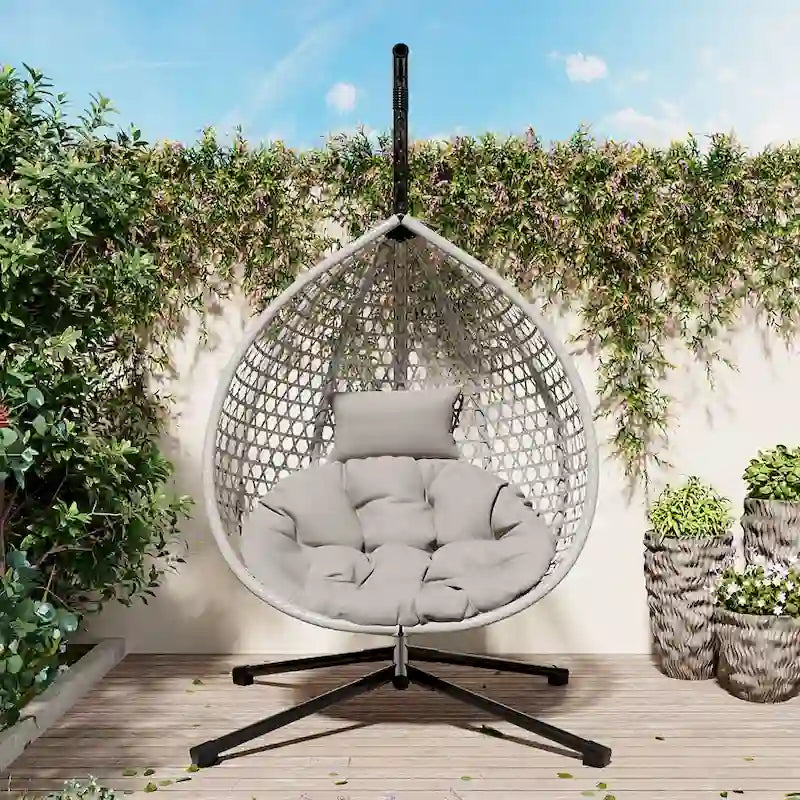 Fauteuil suspendu polyvalent pour l'intérieur et l'extérieur, en rotin PE, avec support et coussin.