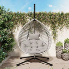 Fauteuil suspendu polyvalent pour l'intérieur et l'extérieur, en rotin PE, avec support et coussin.