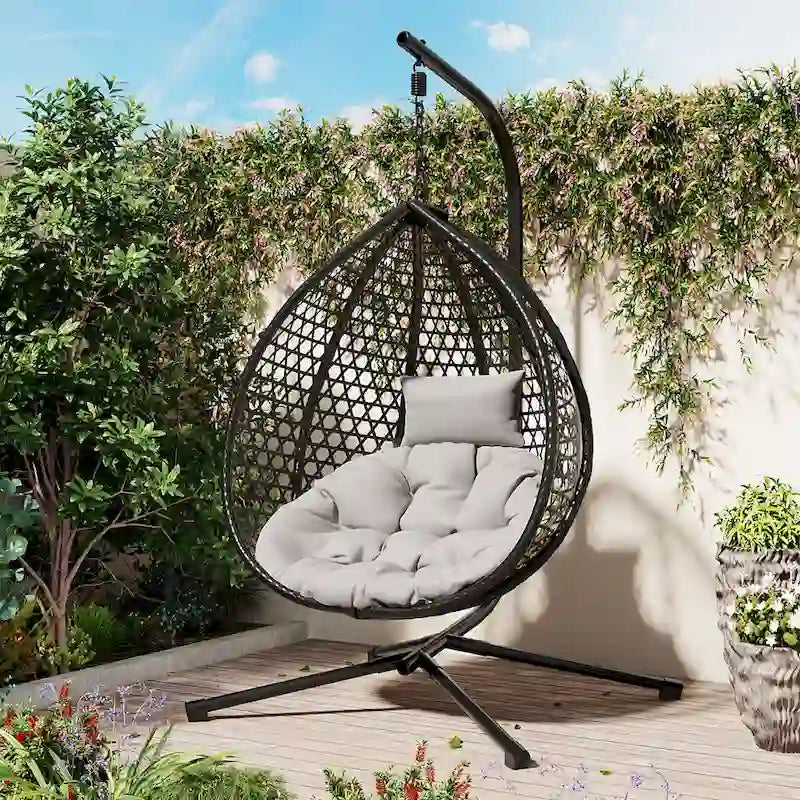 Fauteuil suspendu polyvalent pour l'intérieur et l'extérieur, en rotin PE, avec support et coussin.