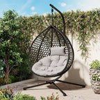 Fauteuil suspendu polyvalent pour l'intérieur et l'extérieur, en rotin PE, avec support et coussin.