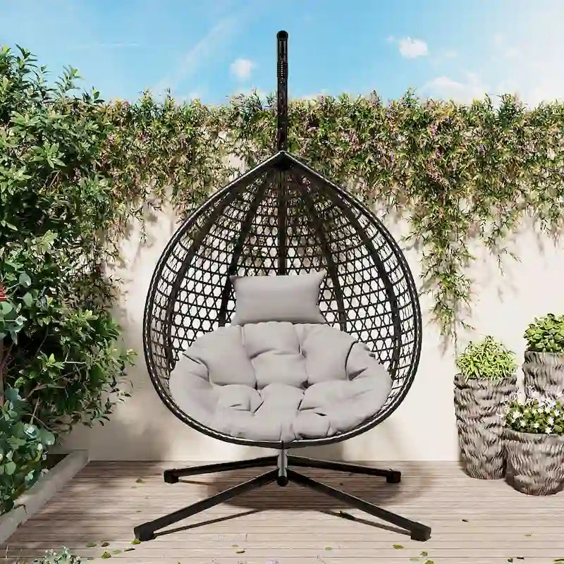 Fauteuil suspendu polyvalent pour l'intérieur et l'extérieur, en rotin PE, avec support et coussin.