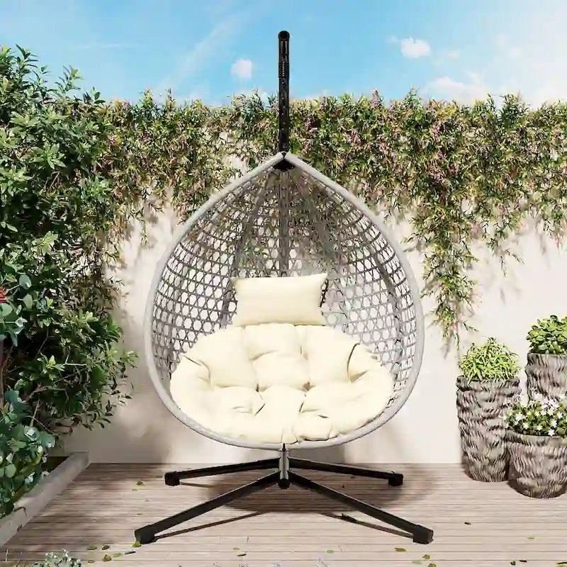 Fauteuil suspendu polyvalent pour l'intérieur et l'extérieur, en rotin PE, avec support et coussin.