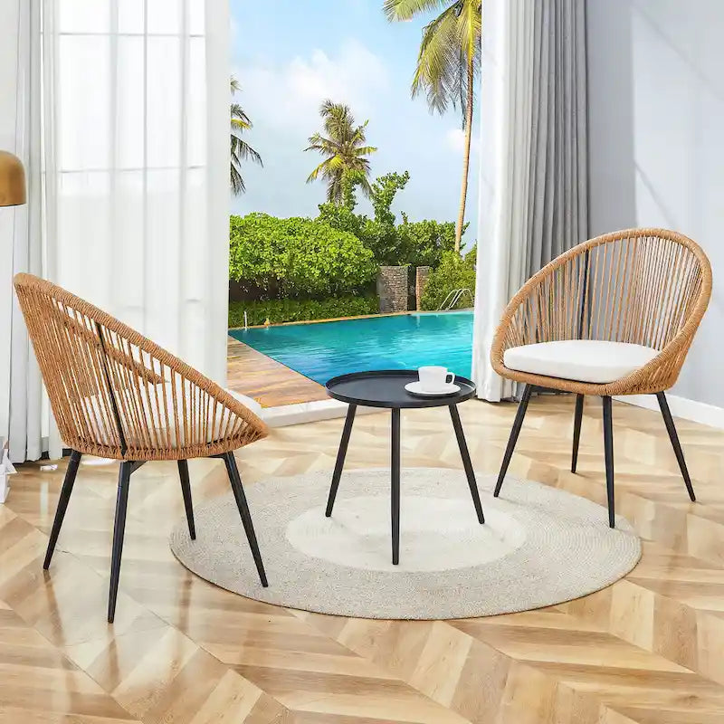 Ensemble repas décontracté pour balcon extérieur, composé d'une table basse ronde moderne anti-déversement, de deux chaises pivotantes en rotin et de coussins.