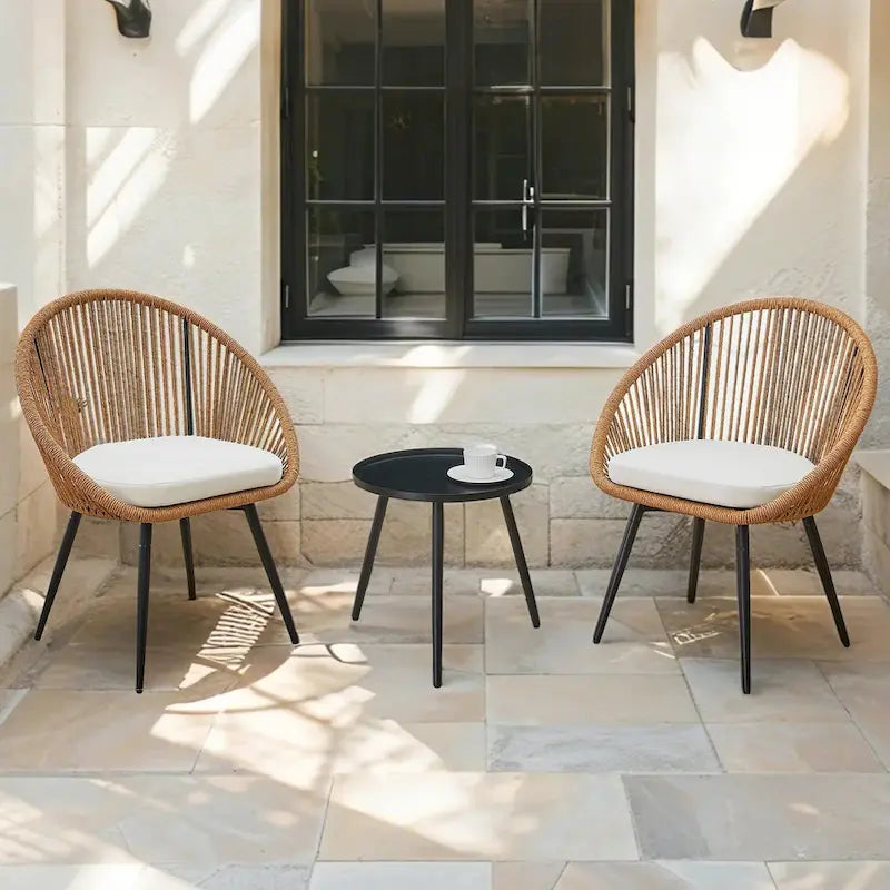 Ensemble repas décontracté pour balcon extérieur, composé d'une table basse ronde moderne anti-déversement, de deux chaises pivotantes en rotin et de coussins.